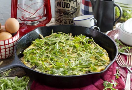 gluten-free frittata made with Nature's Yoke eggs, filled with bacon and mushrooms and topped with fresh arugula in cast iron skillet
